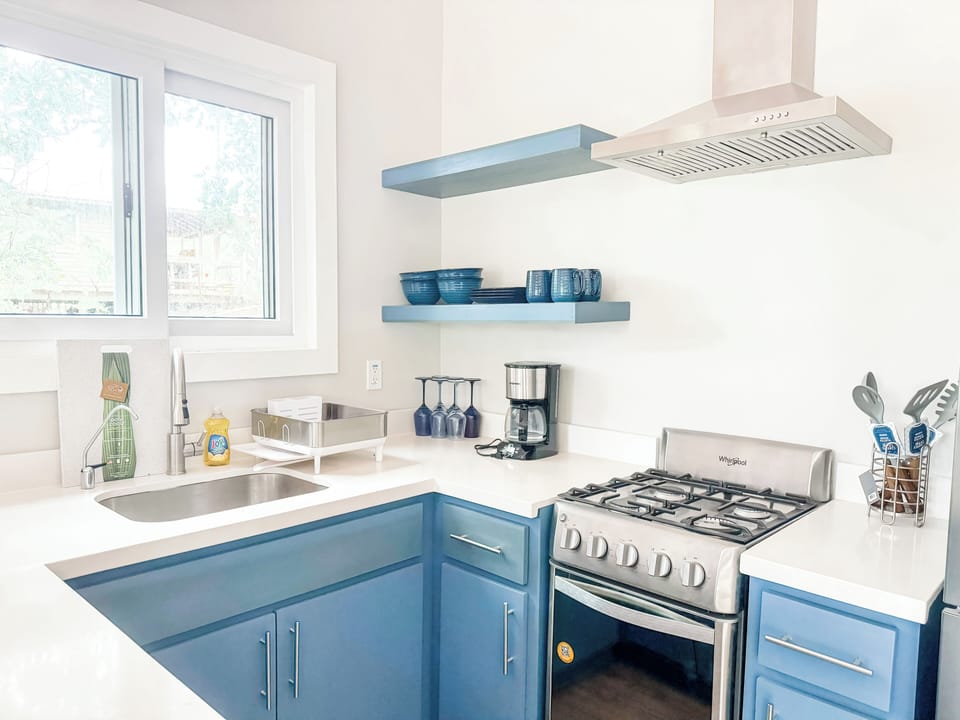 Kitchen with gas stove and full size refrigerator.