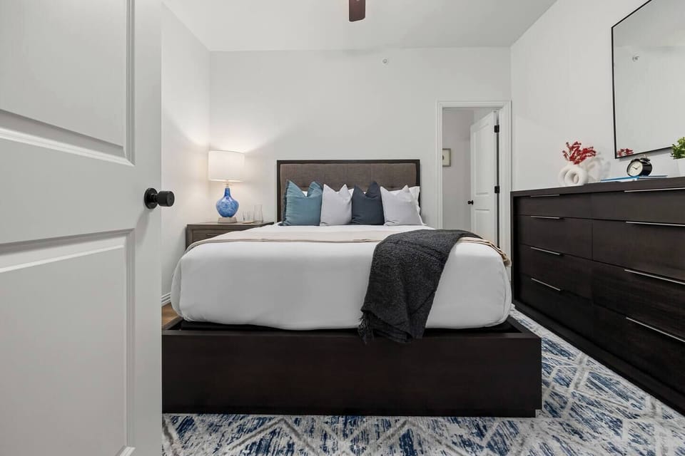 Second Bedroom (Upper Floor): Queen bed with hotel-quality linens, 43" Smart TV, and a private ensuite with a large vanity and combination shower/tub.