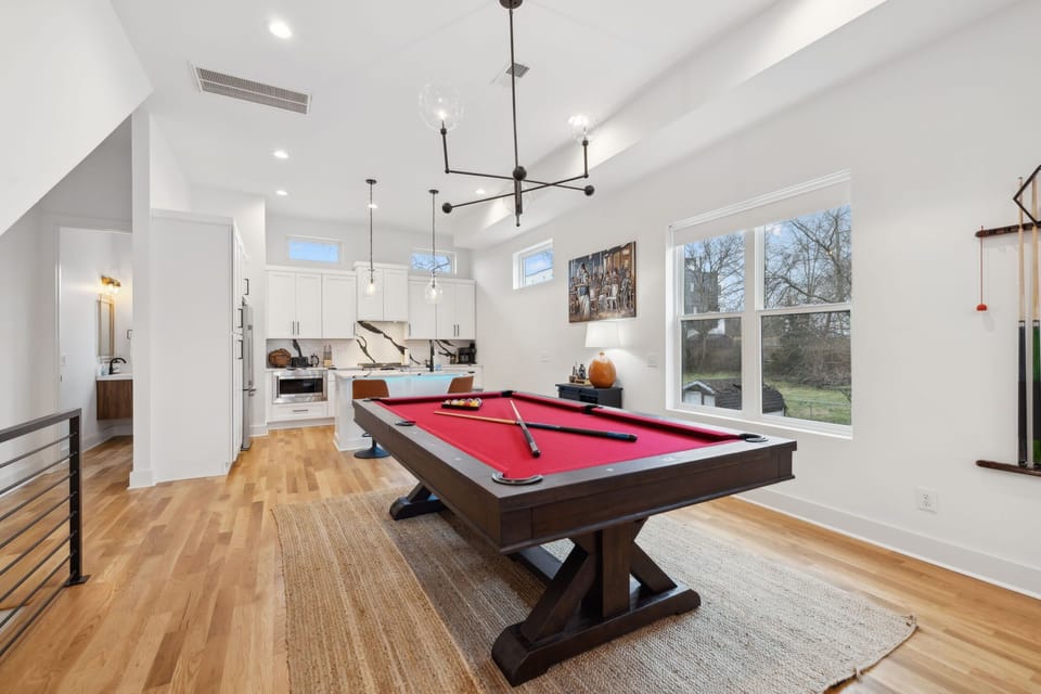 Living Room: Gather with friends in this modern living area featuring a pool table, fully equipped kitchen, and stylish decor throughout.