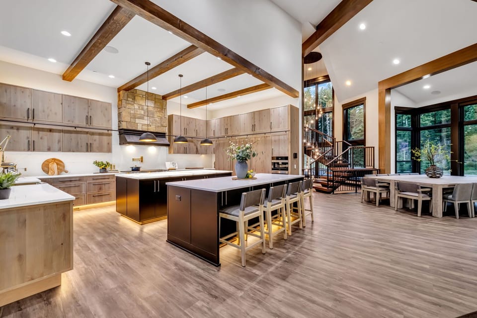 Grand Retreat - Open-Concept Kitchen and Dining Gallery with a Striking Architectural Staircase.