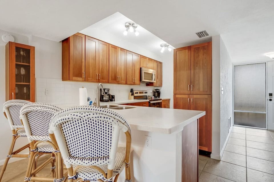Kitchen view from the bar — everything you need for a home-cooked meal, plus the convenience of an in-unit washer and dryer just steps away.
