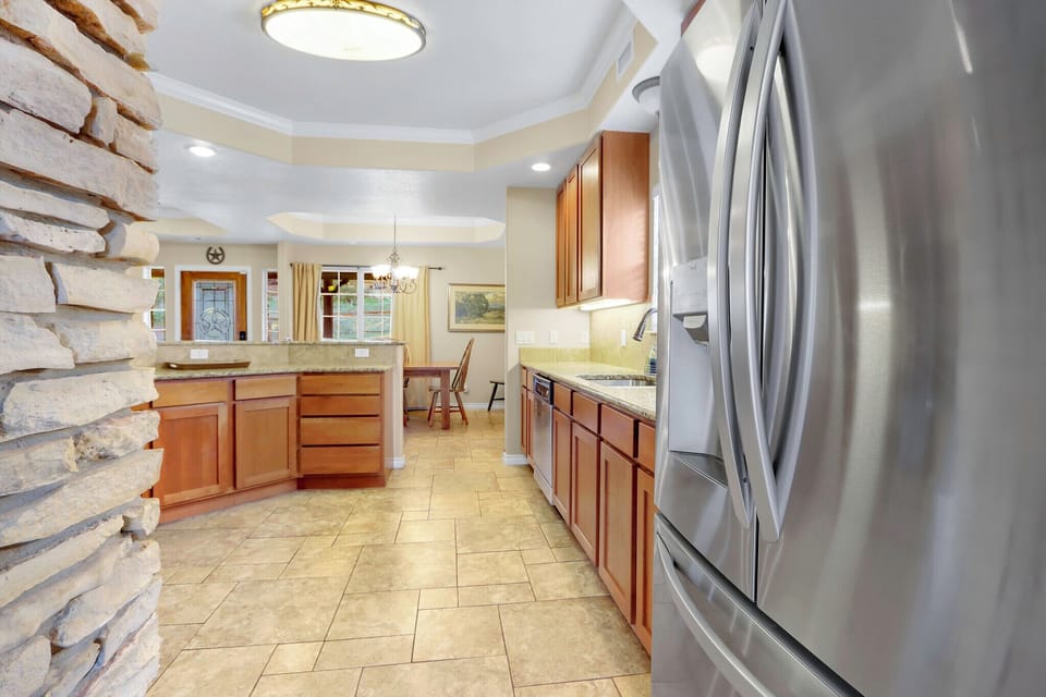 Alternate view of the kitchen showing the refrigerator and sink location.
