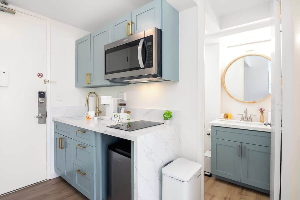 Enjoy the convenience of a contemporary kitchenette, complete with a microwave and cooktop, perfectly complementing the sleek, updated bathroom.