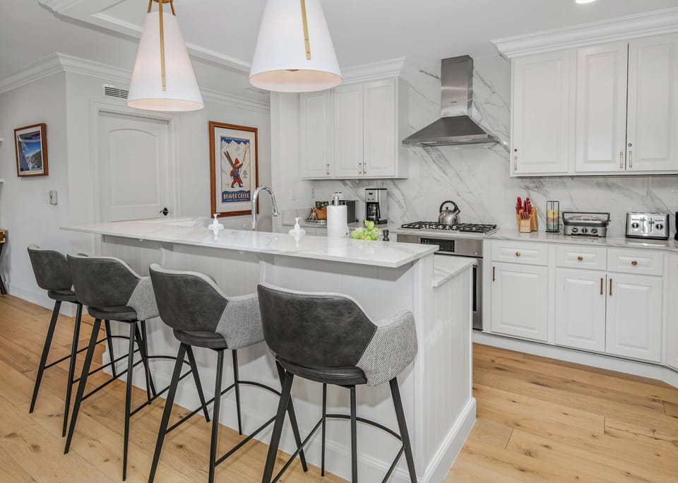 Gather at your bright kitchen island where sleek marble countertops meet modern appliances. Enjoy morning coffee at the stylish bar seating under elegant pendant lighting.