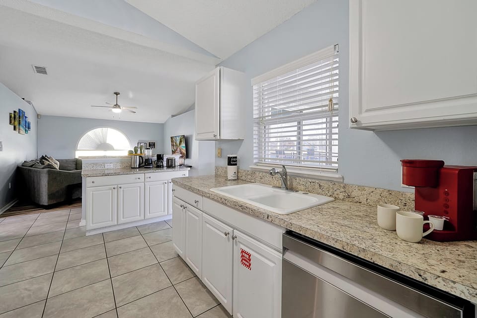 This modern kitchen features white cabinetry, granite countertops. Overlooks the living room for easy entertaining!
