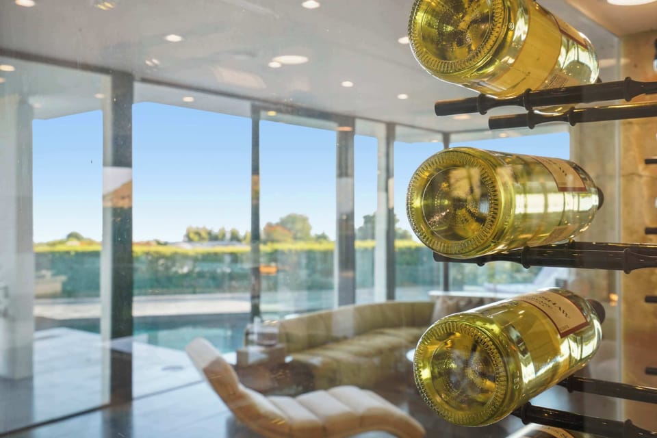 Sleek, modern wine rack framed by floor-to-ceiling glass, a perfect touch of sophistication.