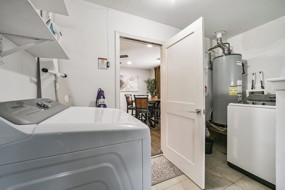 Conveniently located laundry room with a washer, dryer, and essential laundry supplies. Perfect for longer stays, ensuring guests have everything needed to refresh their wardrobe during their stay.