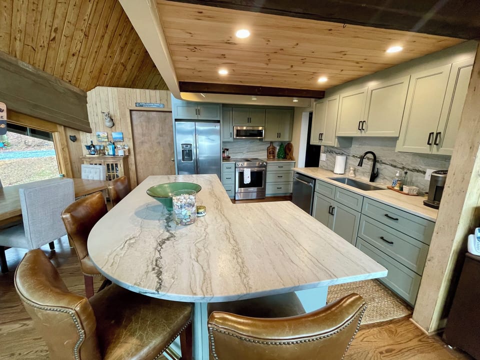 Kitchen with electric range, Keurig coffee maker, & bar stools