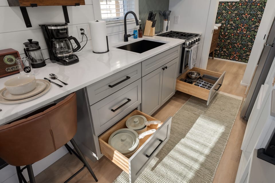 Kitchenette close-up at Hughes — coffee maker, sink, counter space, and pantry basics stocked on arrival