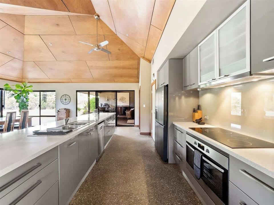 The fully equipped kitchen features a long island bench, sleek cabinetry, and all the essentials for gourmet dinners or lazy breakfasts.