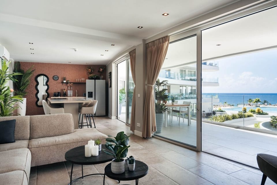Relax in this modern, sun-filled living area with direct access to the balcony and beautiful sea views.