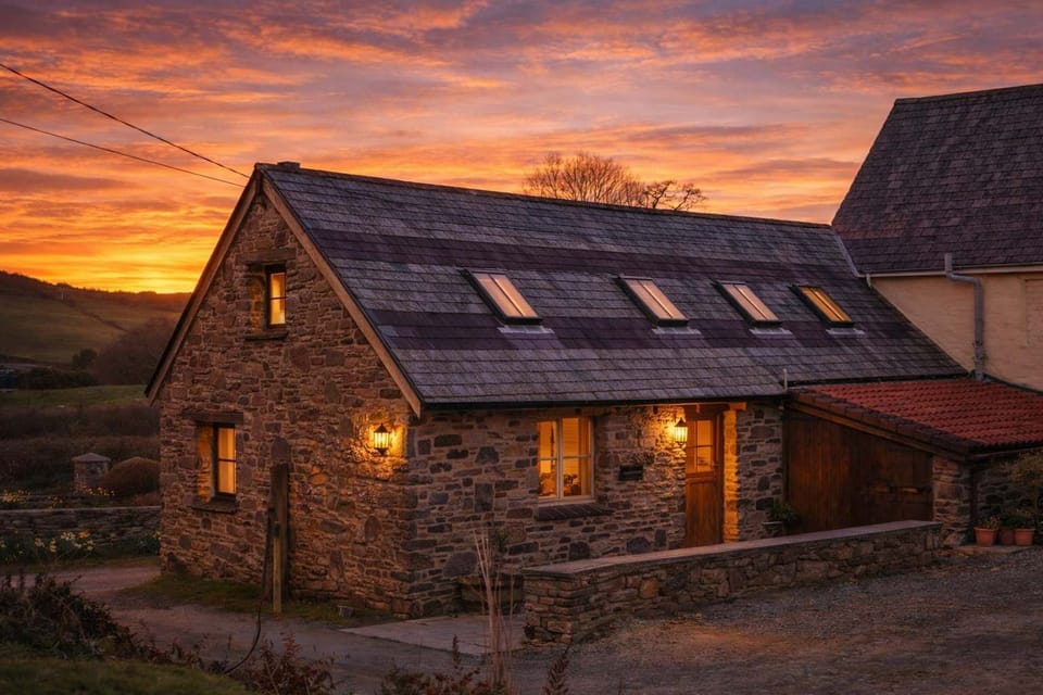 Warm sunset light settles over the front of Summercot in North Devon, setting the tone for a relaxed coastal escape. A welcoming first glimpse of this comfortable luxury barn, perfectly placed for beaches, countryside walks and laid-back evenings.