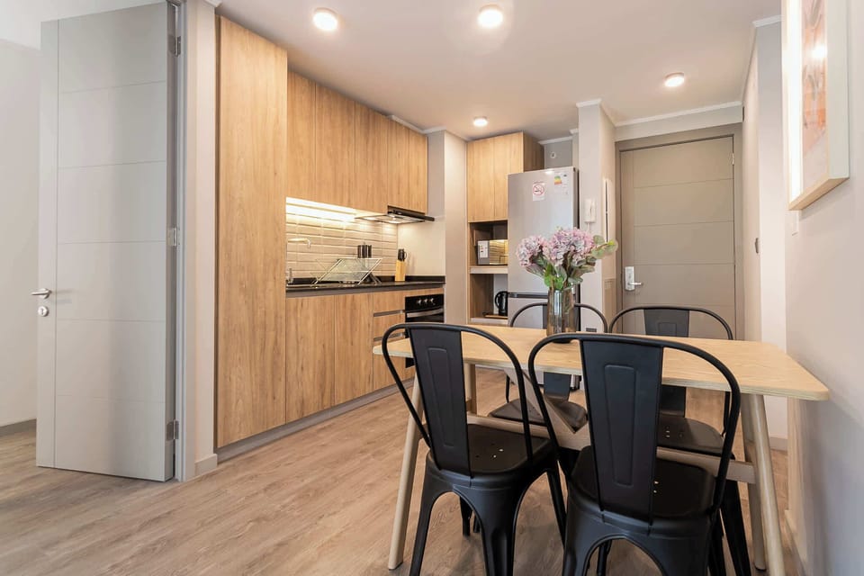 Sleek and modern kitchen with cozy dining area, perfect for enjoying a meal in style.