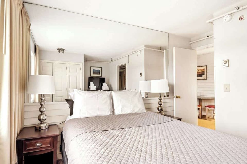 Relax in style in this queen bedroom adorned with a TV and dresser. 