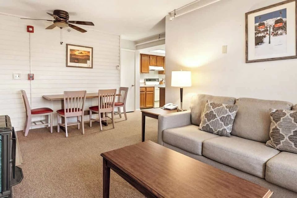 Embrace the warmth of a crackling fireplace, the comfort of a couch, and the charm of a dining table in this inviting living room.