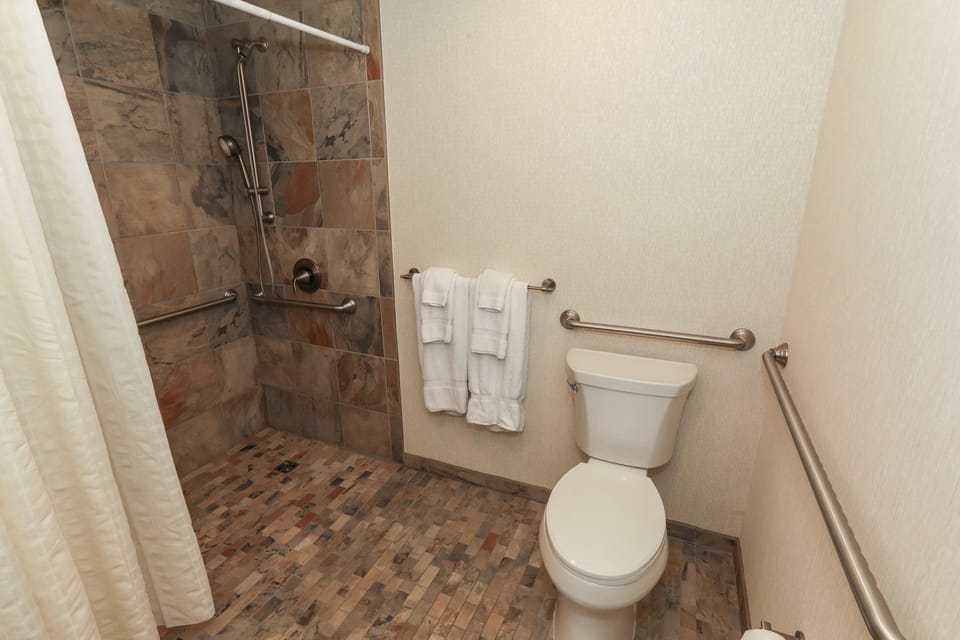 Modern bathroom with a walk-in shower and fresh towels, offering a relaxing experience.