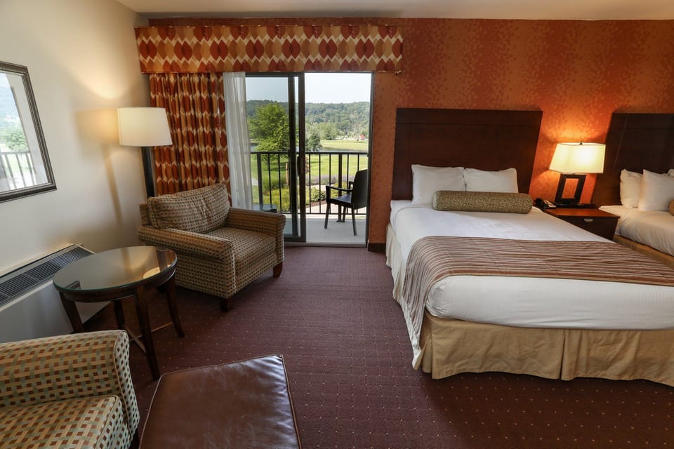 Spacious guest room with two plush beds and a seating area, offering comfort and relaxation.