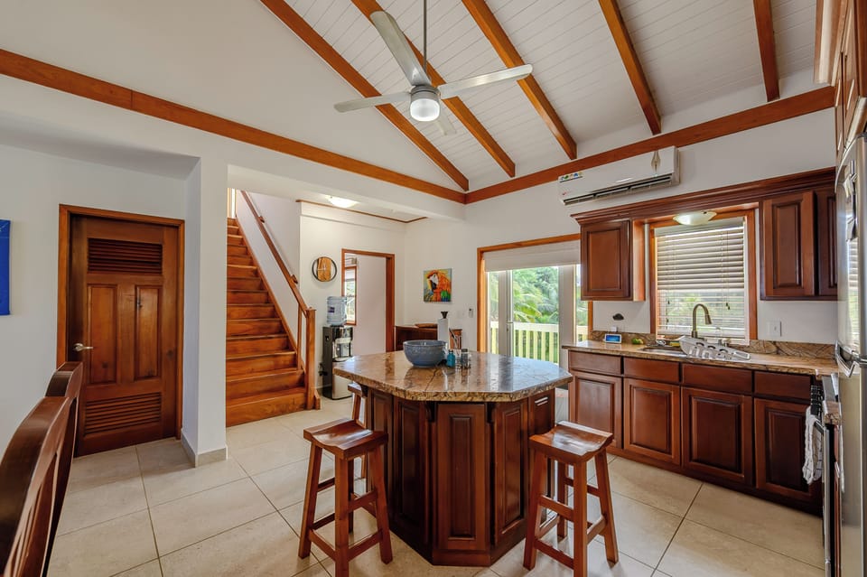 The kitchen, stairs to Bedroom 1, and door to half bath (L) laundry room (R)