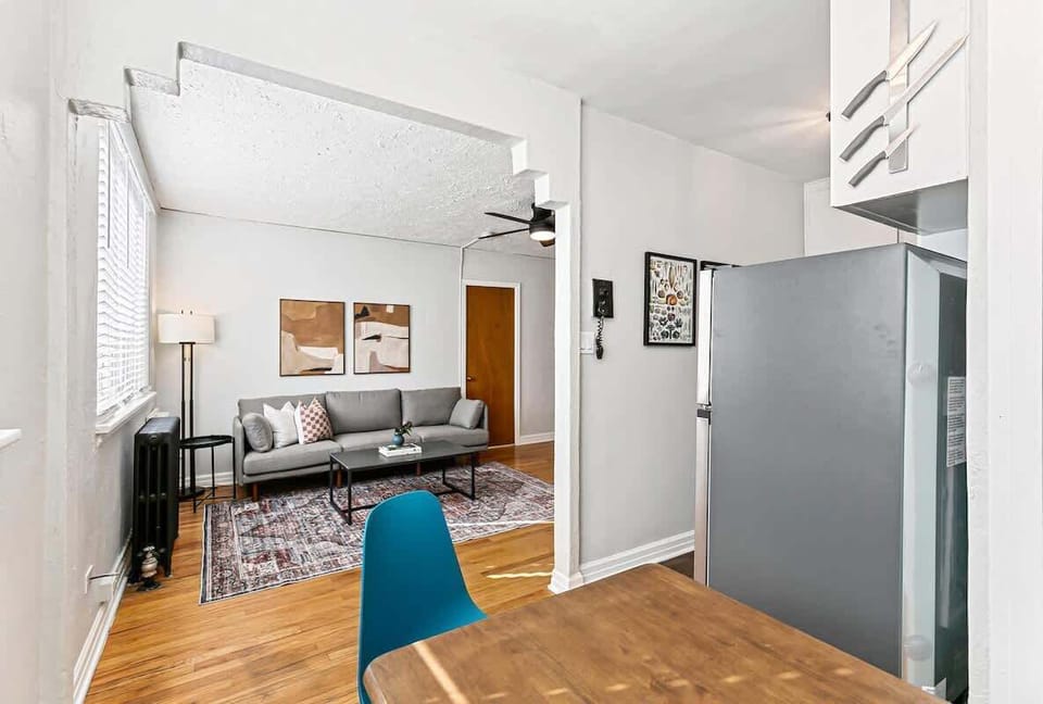 The wide historical arch opens between the dining area and living room