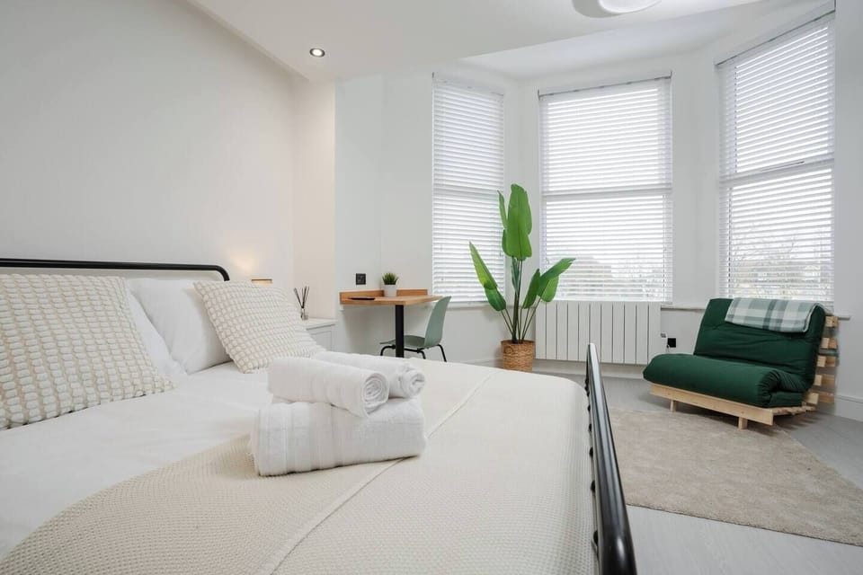 The room includes a double bed, sofa bed for one guest, Smart TV with Netflix, workspace, washing machine, kitchenette, mini fridge with freezer, and USB bedside plugs.
