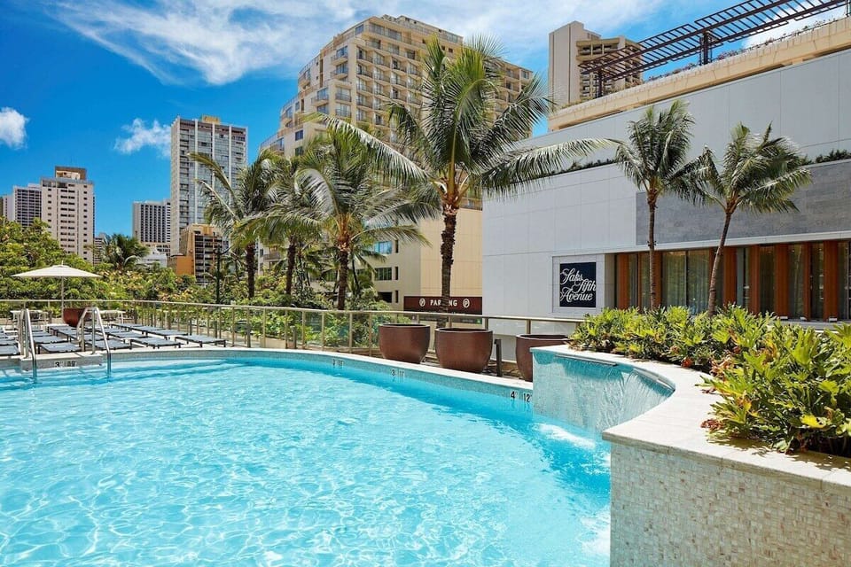 Dive into a sunlit pool framed by swaying palms.