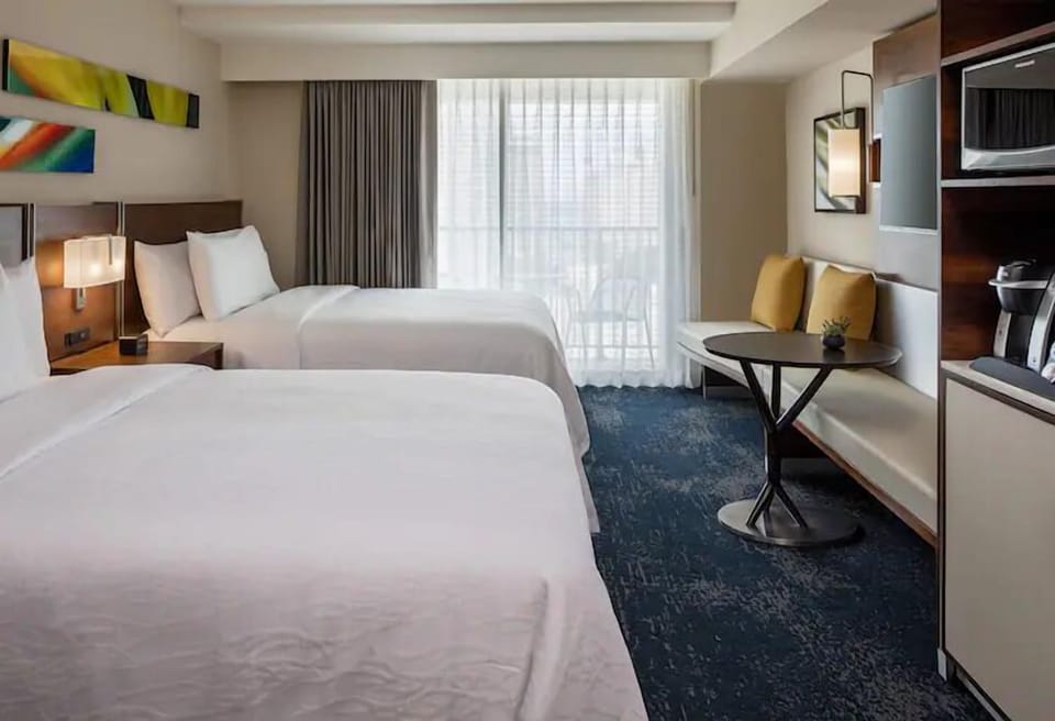 Unwind in bright doubles with crisp linens and city light.