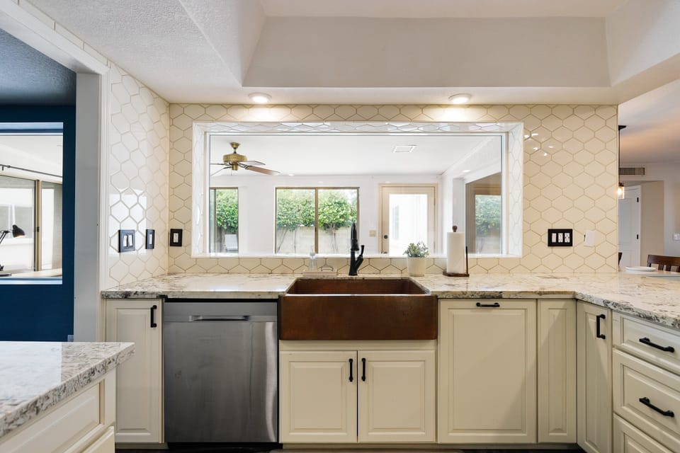 The fully equipped modern kitchen is stocked with all culinary essentials, stainless-steel appliances, and breakfast bar seating.