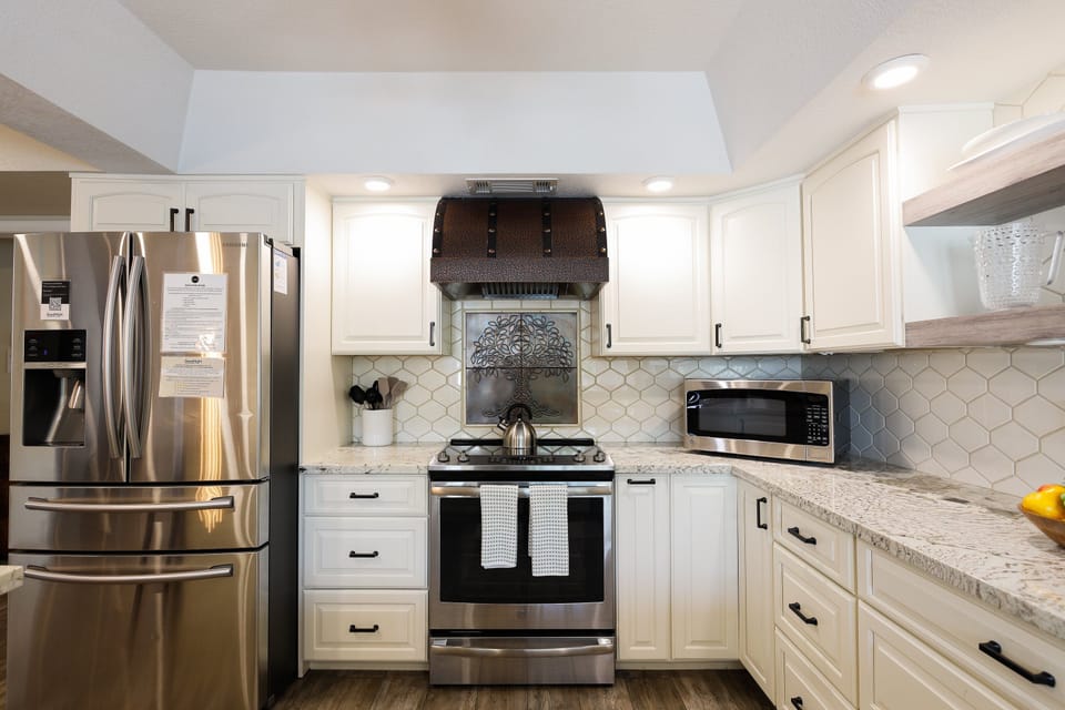 The fully equipped modern kitchen is stocked with all culinary essentials, stainless-steel appliances, and breakfast bar seating.