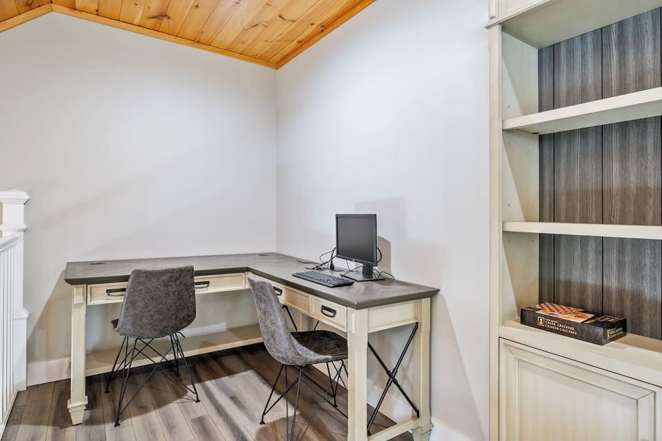 Stay productive in style! This cozy workspace features a spacious desk, comfy seating, and rustic charm—perfect for remote work or trip planning. Plus, built-in shelves add character and a fun game break!