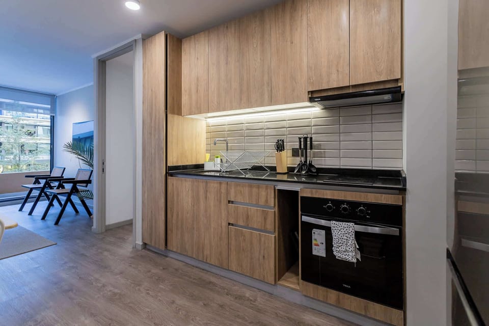 Sleek, modern kitchen with ample natural light and stylish dining area, perfect for enjoying a cozy meal.