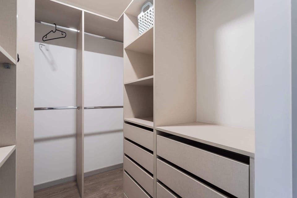 Cozy twin bedroom with modern decor and ample natural light, perfect for a restful stay.