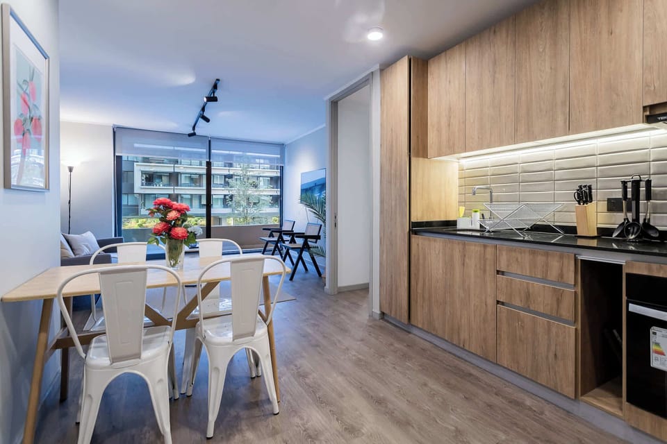 Bright and modern kitchen with a cozy dining area and balcony view, perfect for enjoying your morning coffee.