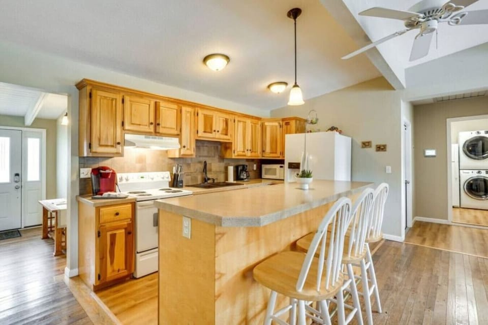 Fully equipped kitchen with a breakfast bar and wooden accents, offering a warm and inviting space for cooking and entertaining.
