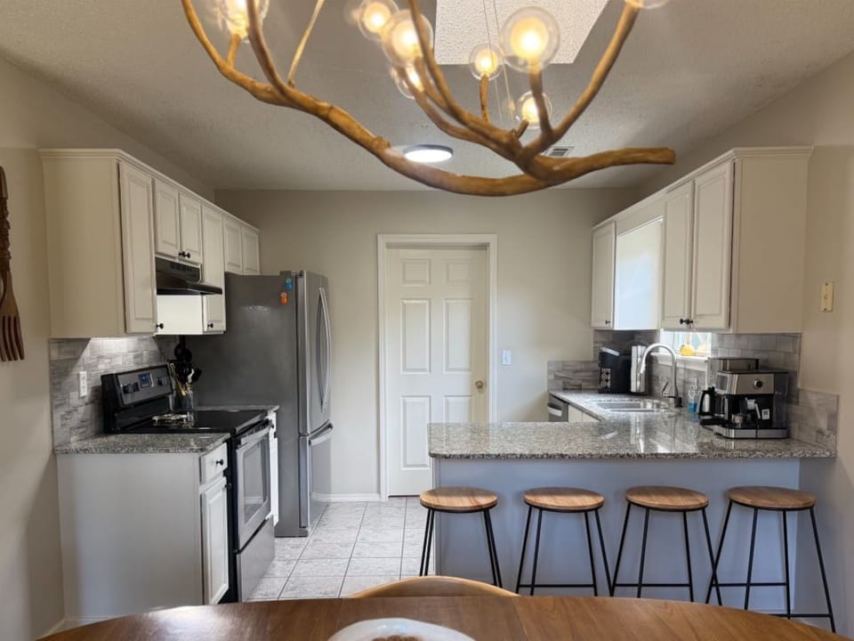 DINE: Enjoy a home-cooked meal in the open dining space, perfect for reconnecting. The compact kitchen is stocked with all your cooking essentials. 
