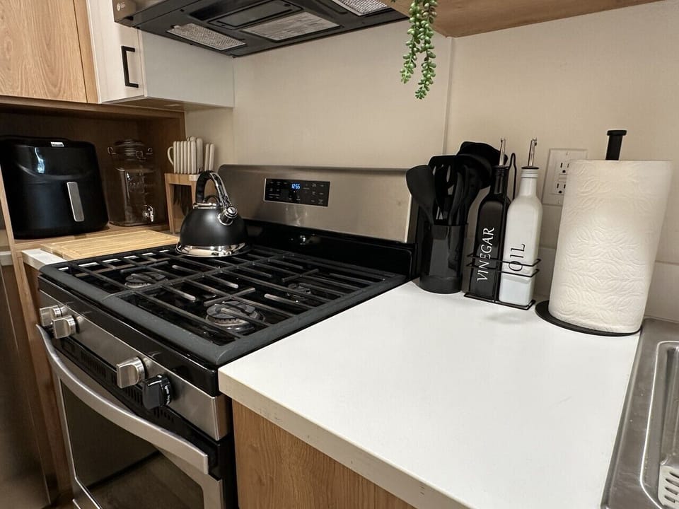 Modern kitchen setup with a gas stove, sleek countertops, and essential cooking tools. Thoughtfully arranged for convenience, making it easy to prepare meals in a clean and stylish space.