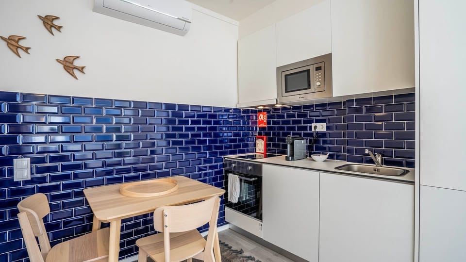 Charming kitchenette with a bold blue tile backsplash, modern appliances, and a cozy dining area. A stylish and functional space for a comfortable stay.
#ModernKitchen #StylishDesign #PortoStay #CozyLiving #TravelPortugal