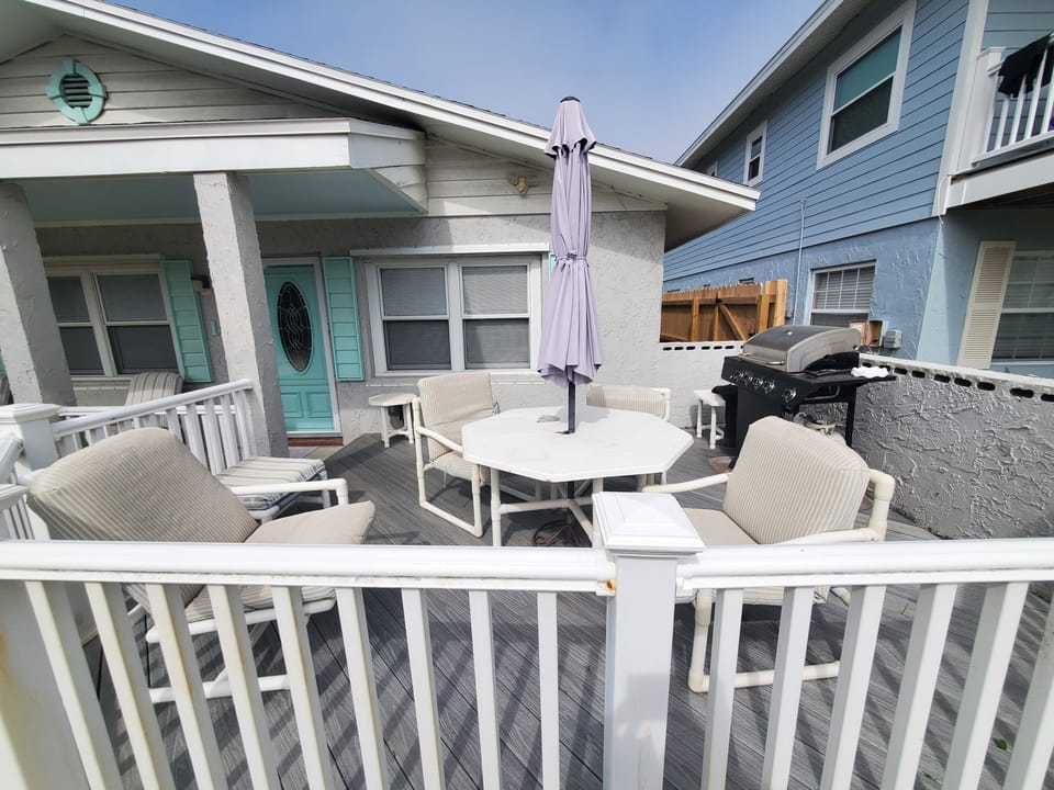 Inviting patio with dining set and BBQ grill, perfect for outdoor meals.