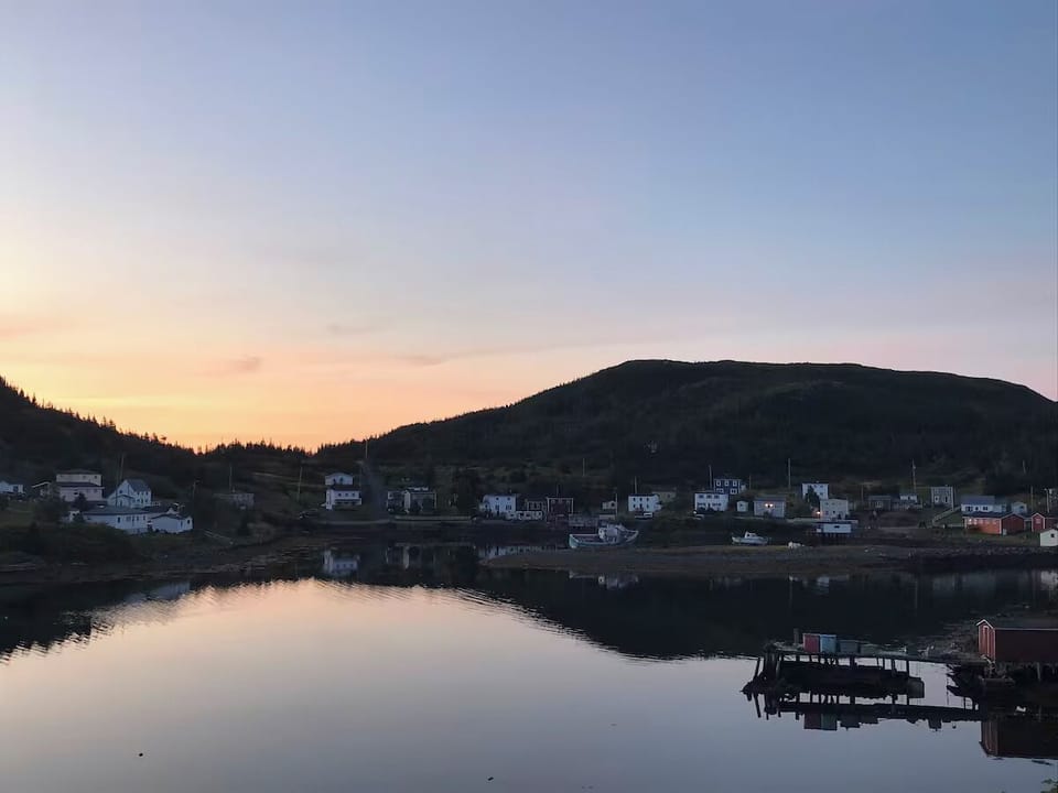 The sun peeking over the hill into the bay early in the morning.