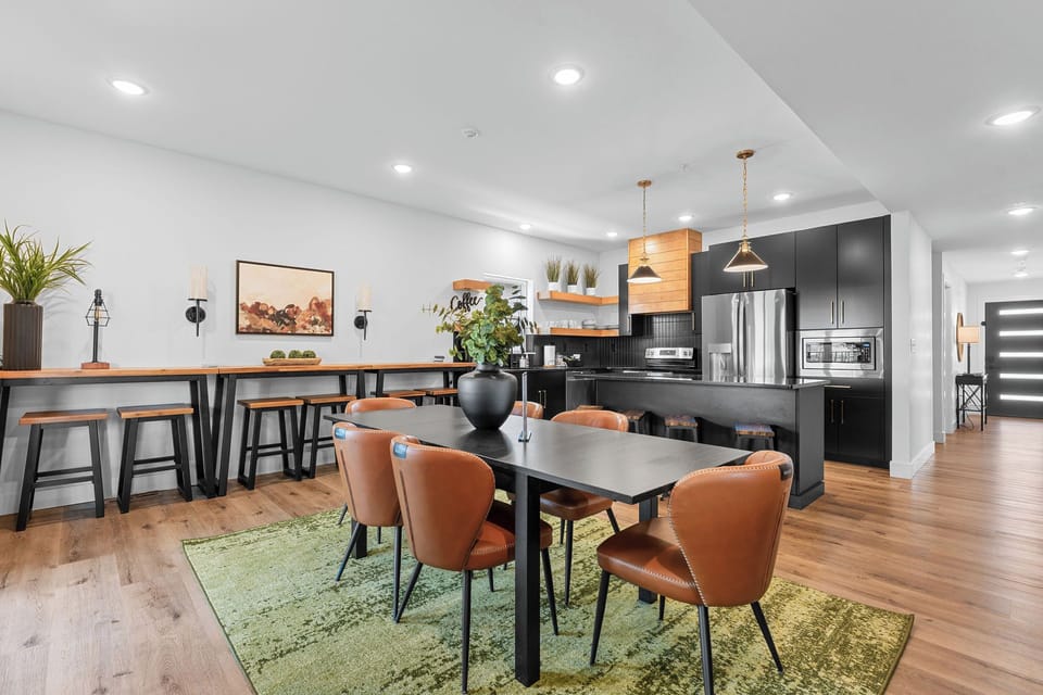 - Spacious dining table perfect for shared meals and game nights
- High-top bar with additional seating and fun “adventure” wall art
- Open-concept design flows effortlessly from kitchen to dining