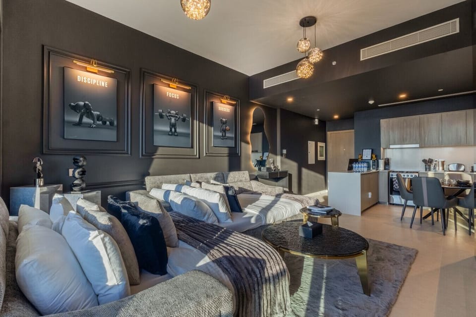 A spacious living room featuring two comfortable sofa beds and a modern dining table, perfect for relaxing and enjoying meals in a luxurious Downtown Dubai vacation home.