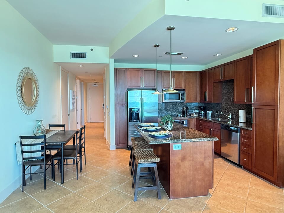 Fully stocked kitchen with items for cooking and vacation. Island and table.  