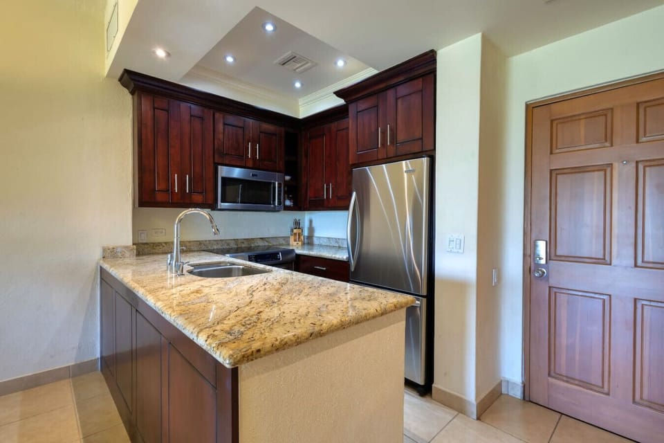 Modern kitchen with granite counters and stainless steel appliances.