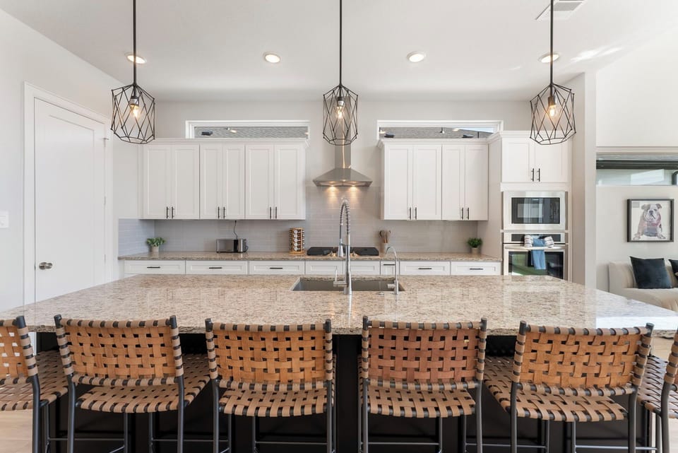 Leather barstools, stainless steel appliances, and modern design.