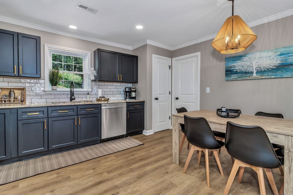 Open-concept dining & fully equipped kitchen — stainless appliances, dark shaker cabinets, modern vacation home Waynesville NC