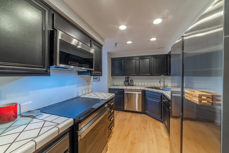 Newly upgraded itchen with stainless steel appliances including an induction stovetop range.