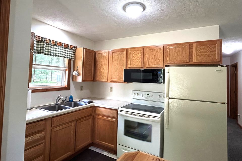 Stove with oven, microwave and full size refrigerator.