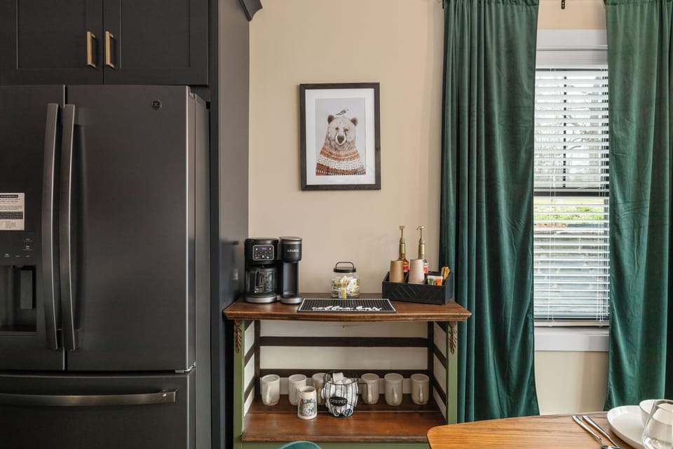 Coffee bar is stocked with drip and k cup coffee maker, syrups, coffee, and tea.