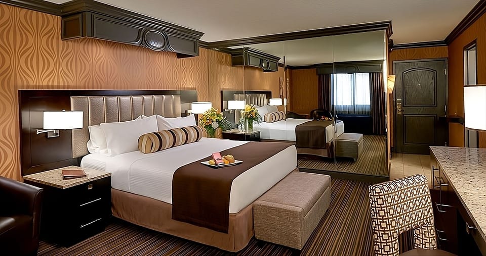 Unwind in a plush king bed with mirrored elegance.
