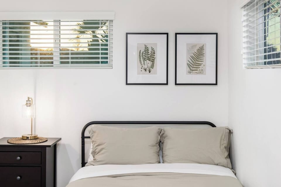 Bright, tastefully decorated bedroom featuring a cozy bed, soothing artwork