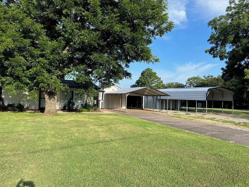 Front yard with covered parking for multiple vehicles, boats, or trailers.
